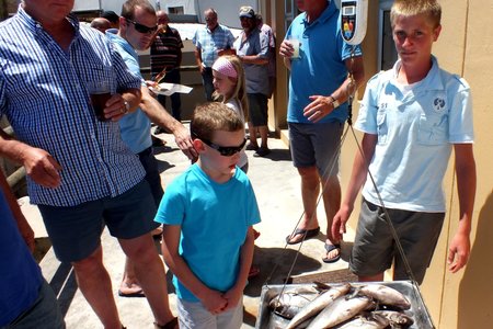 Regs is JP Uys, Juniorvoorloper, met sy vangstes, met ‘n besoekertjie vanaf Pretoria, Simeon Botha wat toekyk en voorsitter Philip Fourie regs